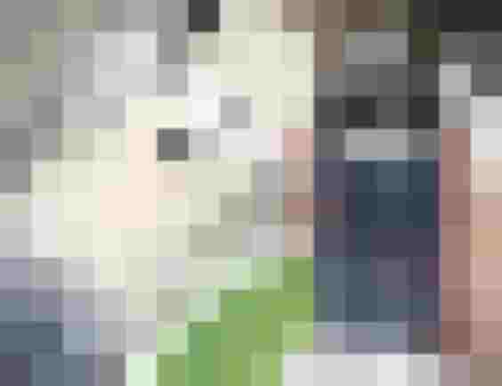 Hand mit Taschenrechner und Euro-Scheinen vor unscharfem Heizungsregler